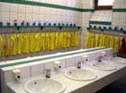 waschraum mit kleinen waschbecken und vielen gelben hantuechern